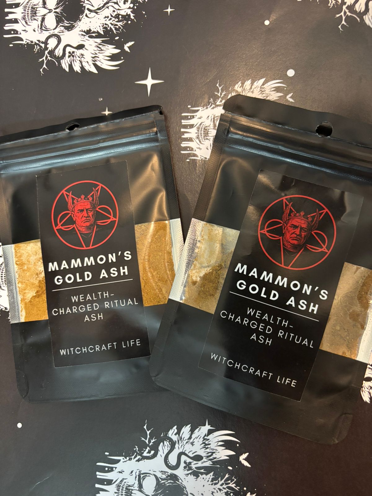 A small ritual vial of Mammon’s Gold Ash placed on a dark altar, surrounded by gold coins, demonic sigils, and burning black candles symbolizing infernal prosperity